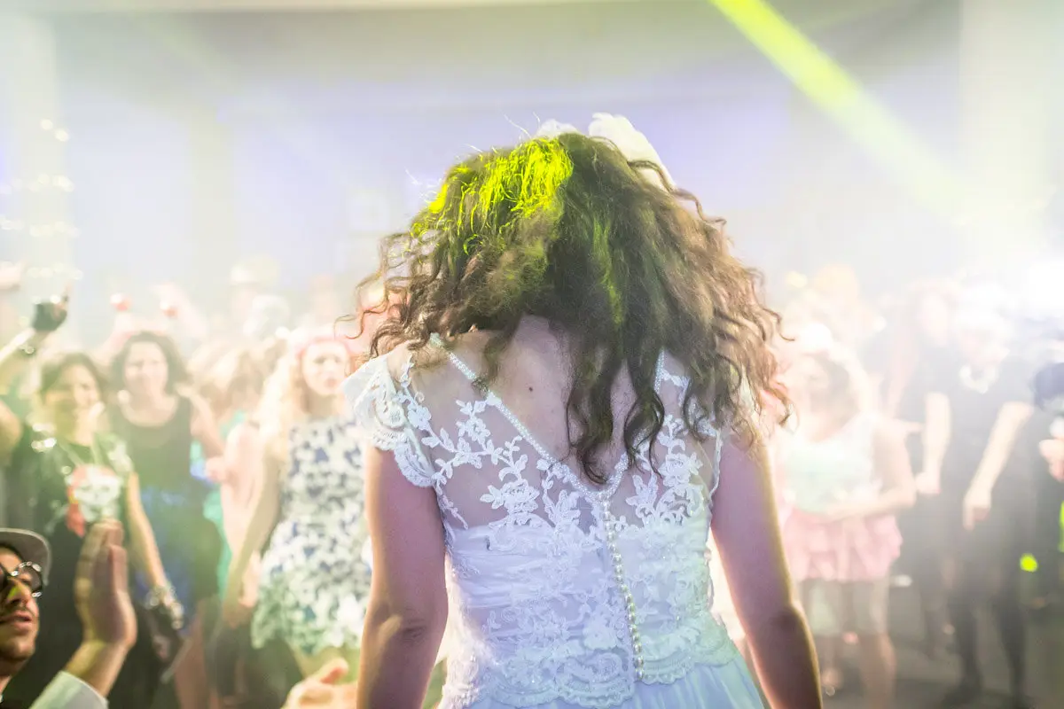 Bride seen from behind facing a dancing crowd