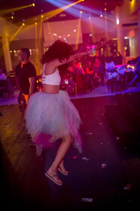 A guest dancing under stage lights at a wedding