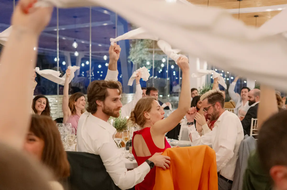 Wedding guests waving napkins at their tables